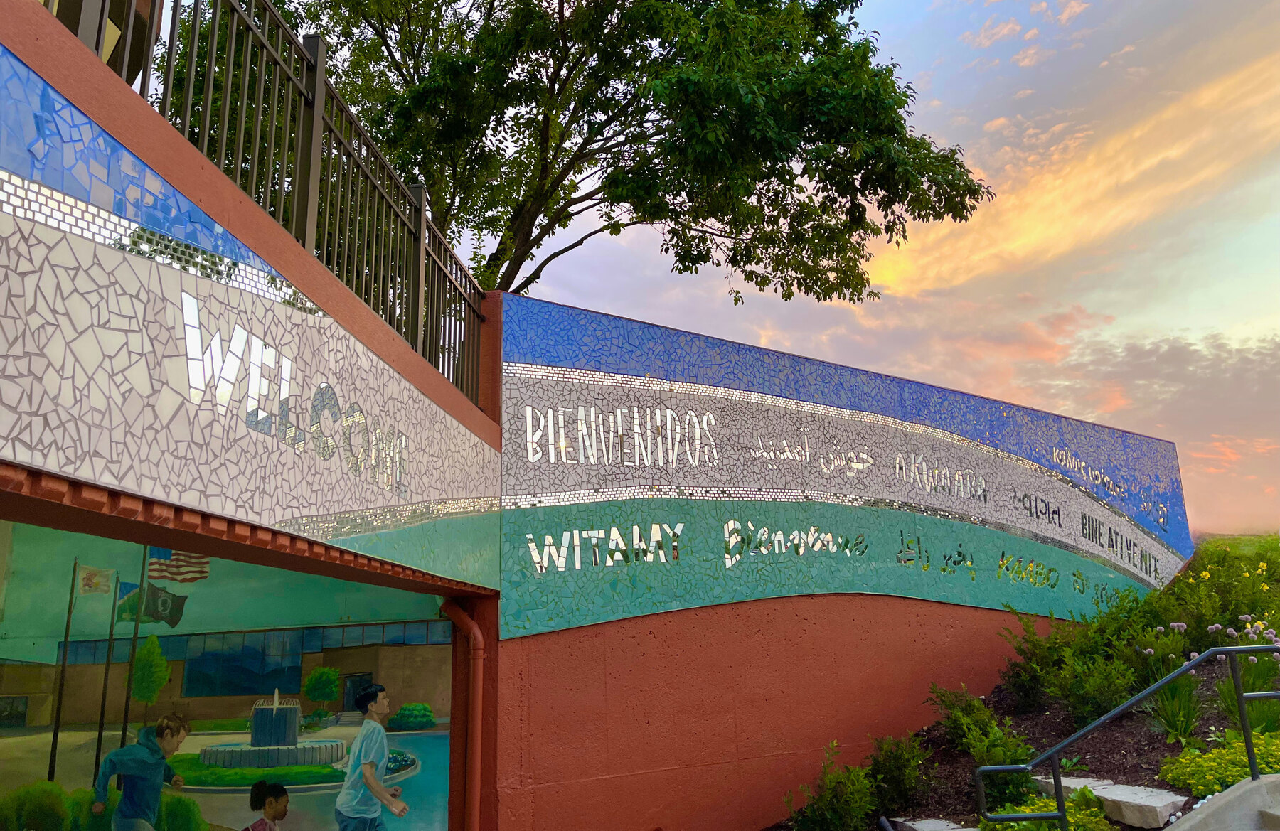 A Reflection of Bolingbrook mosaic beneath trees and a colorful evening sky
